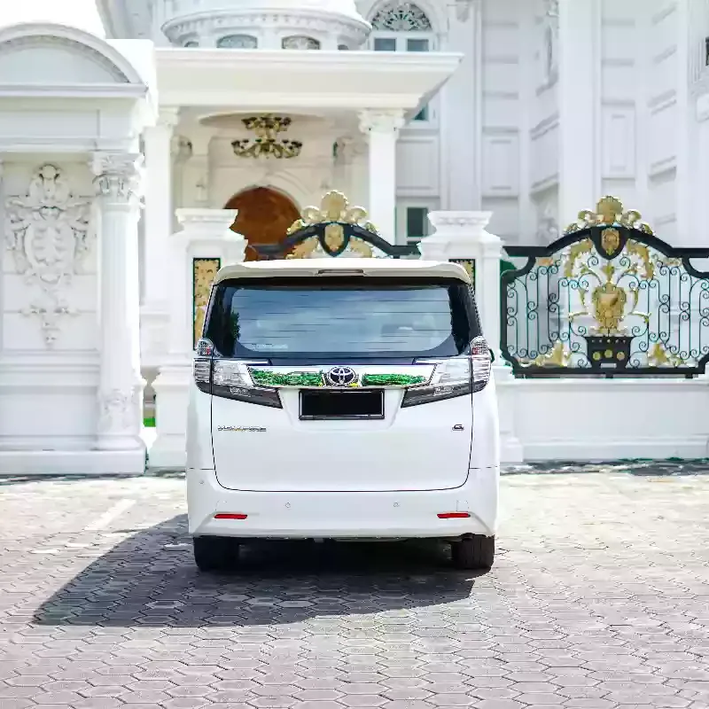 Rear of a white Toyota Vellfire parked at a house