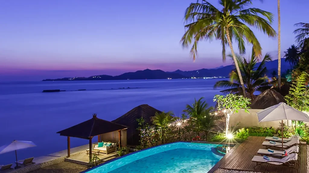Villa infinity pool at dusk with a sea view in Candidasa, Bali