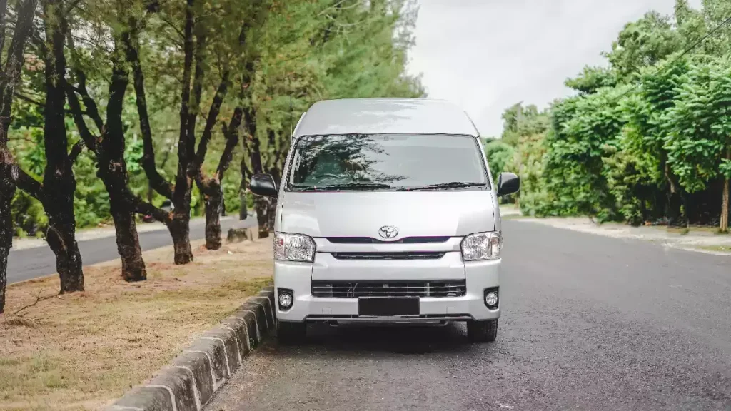 Silver Toyota HiAce Commuter on a tree-lined road