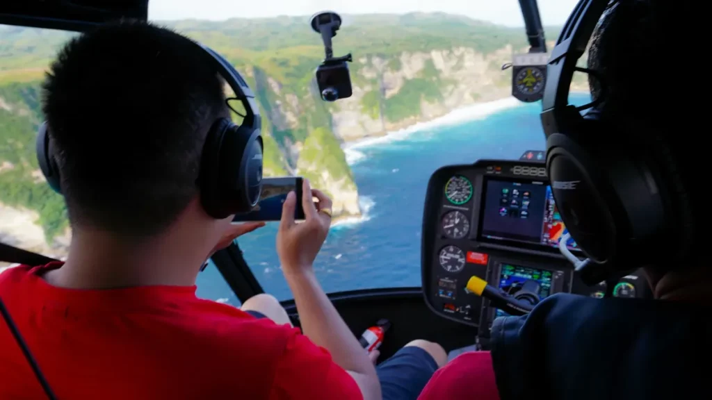 View from a helicopter cockpit over the cliffs of Nusa Penida